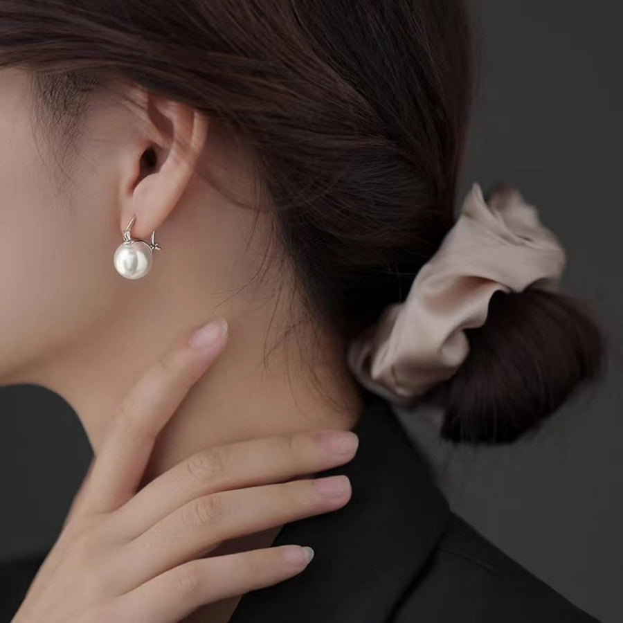 Silver plated pearl hoop earrings with a single large pearl drop.