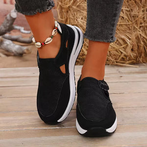 Black breathable cutout slip-on sneakers with white soles and a shell anklet.