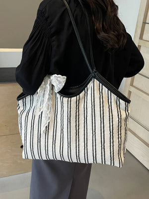 Lace bow striped shopper bag in beige with black trim and straps.