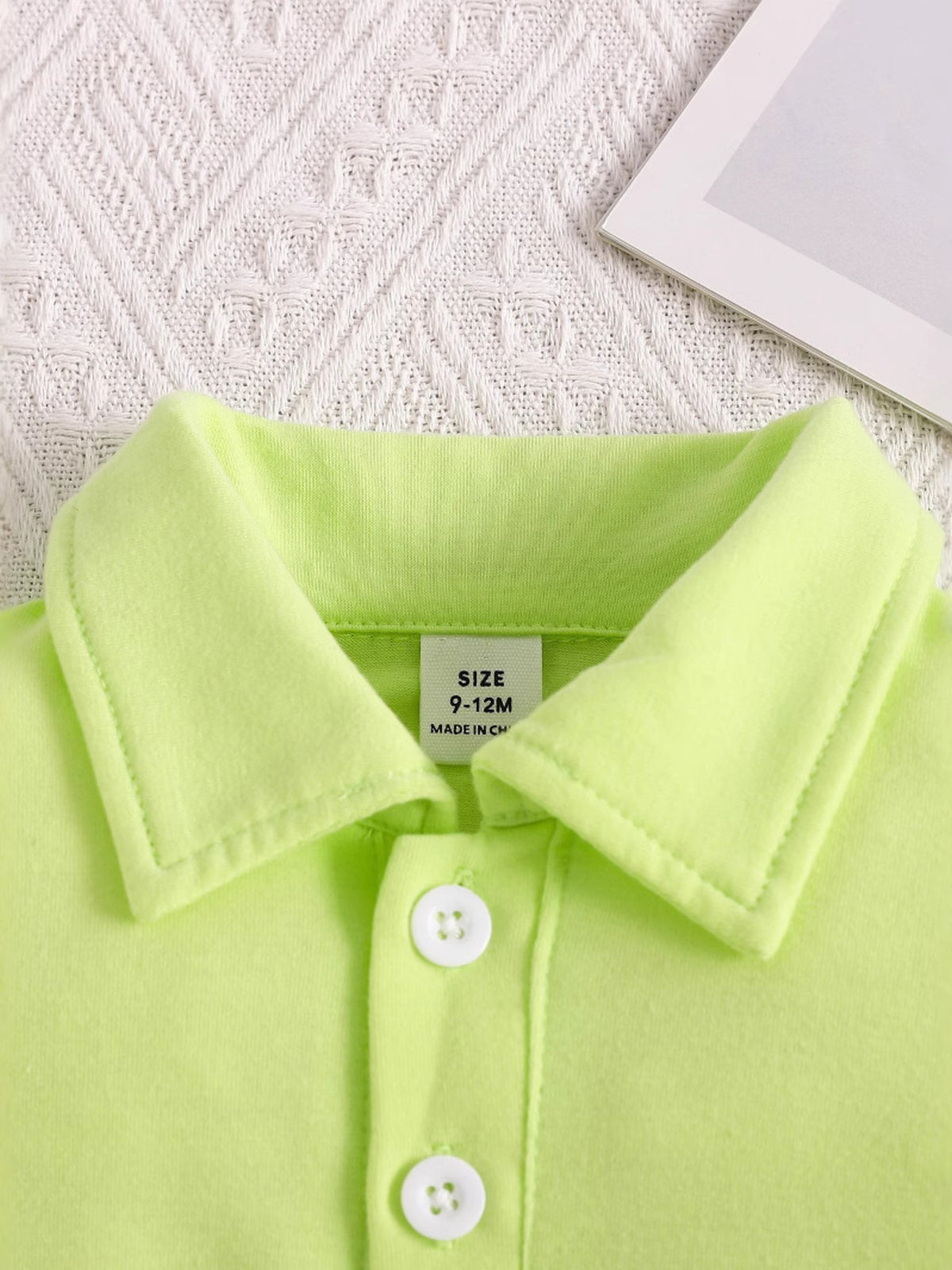 Children's lime green polo shirt with white buttons and a size tag.