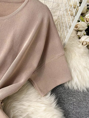 Apricot knit two-piece set with tied waist and wide legs, short sleeves.