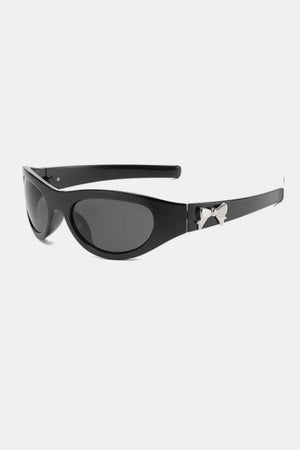 Black sporty shield sunglasses with a silver bow embellishment on the temple.
