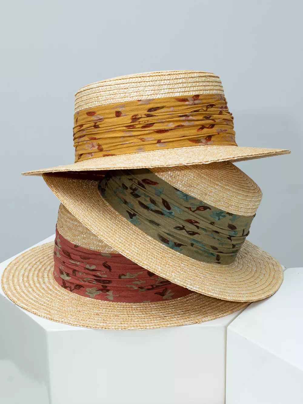 Wheat straw boater hats with ruched floral ribbon in yellow, green, and rust