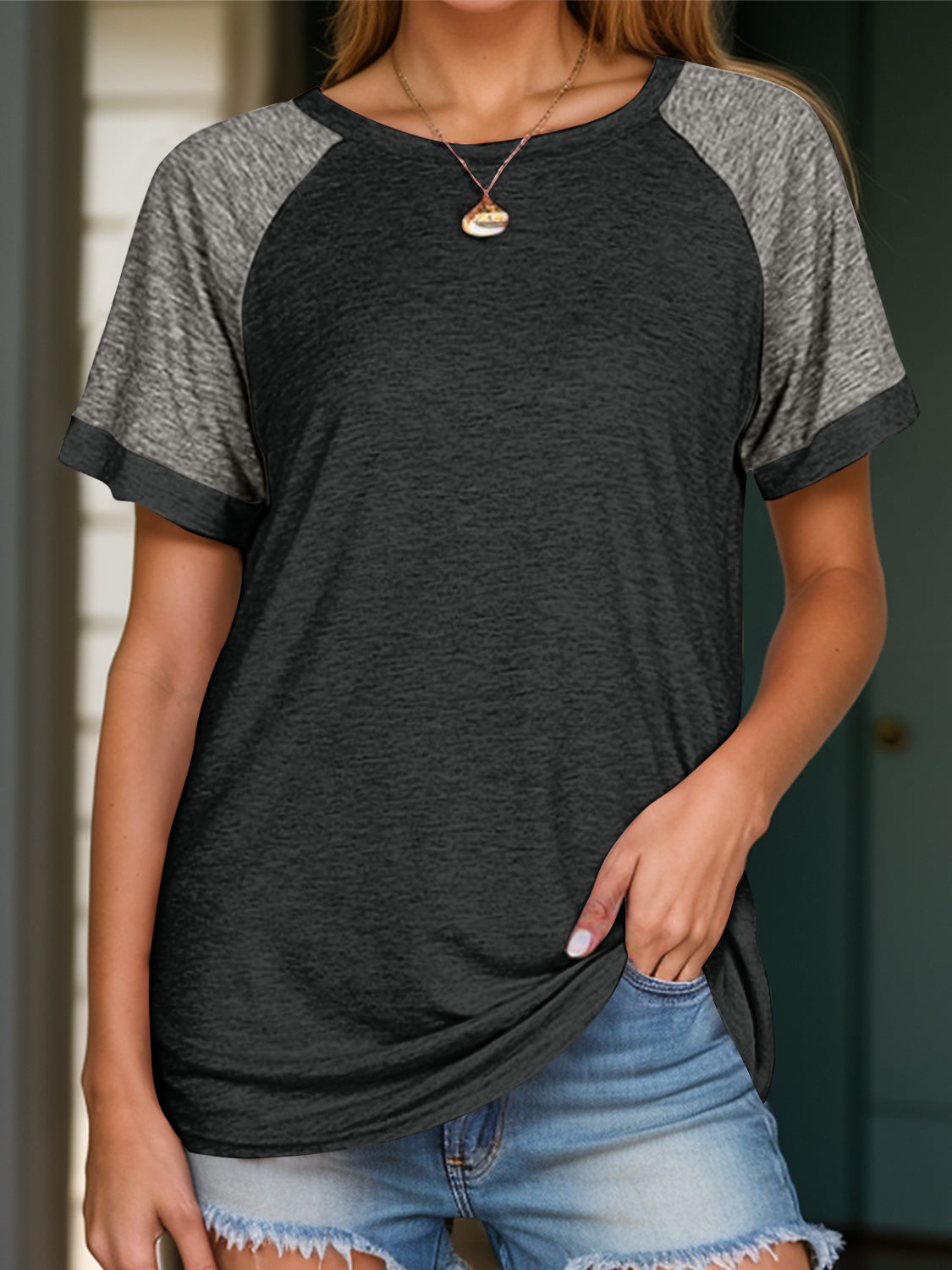 Raglan sleeve tee in dark gray and black with a crew neck and short sleeves.