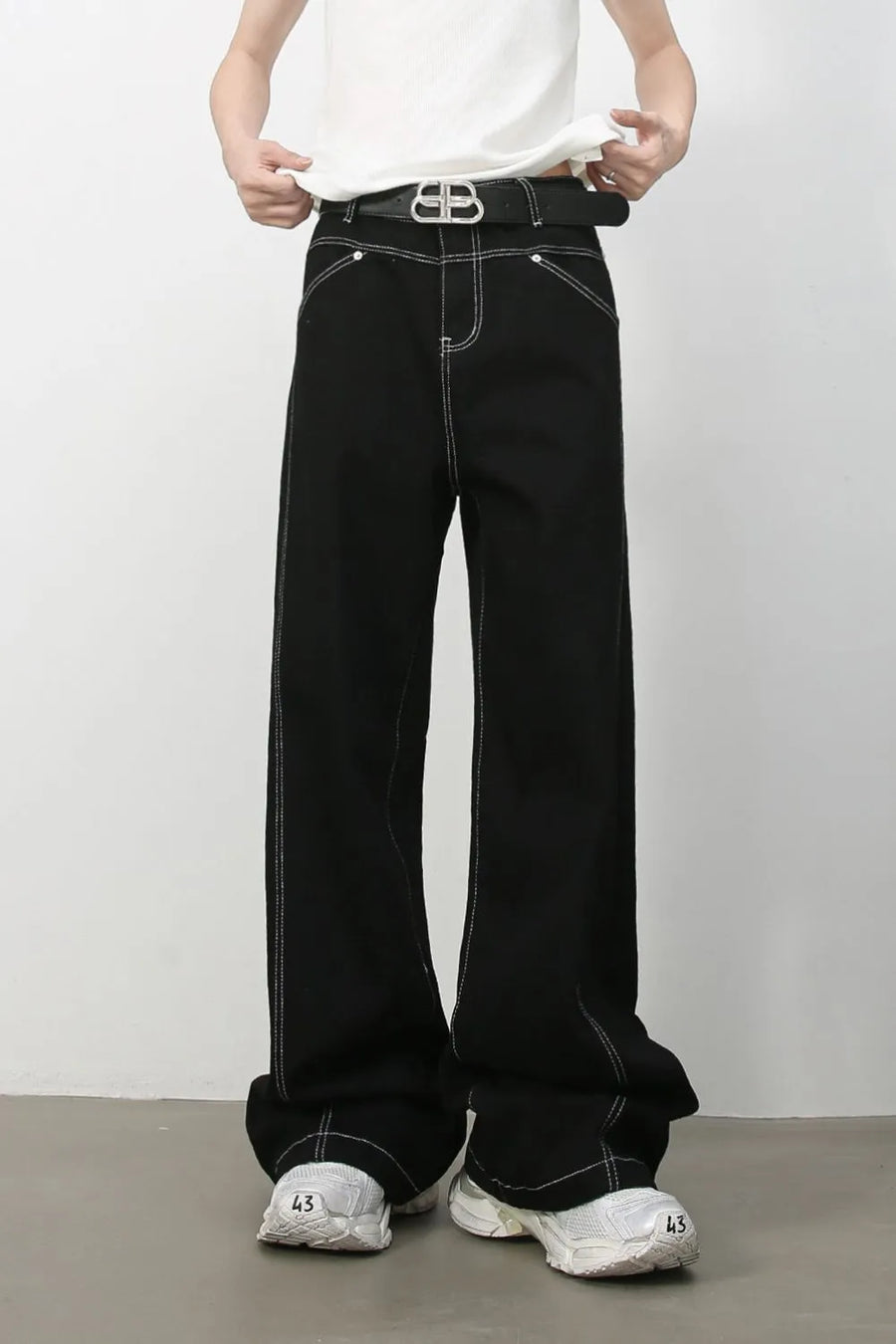 Black relaxed fit denim jeans with contrast white stitching and a wide leg.