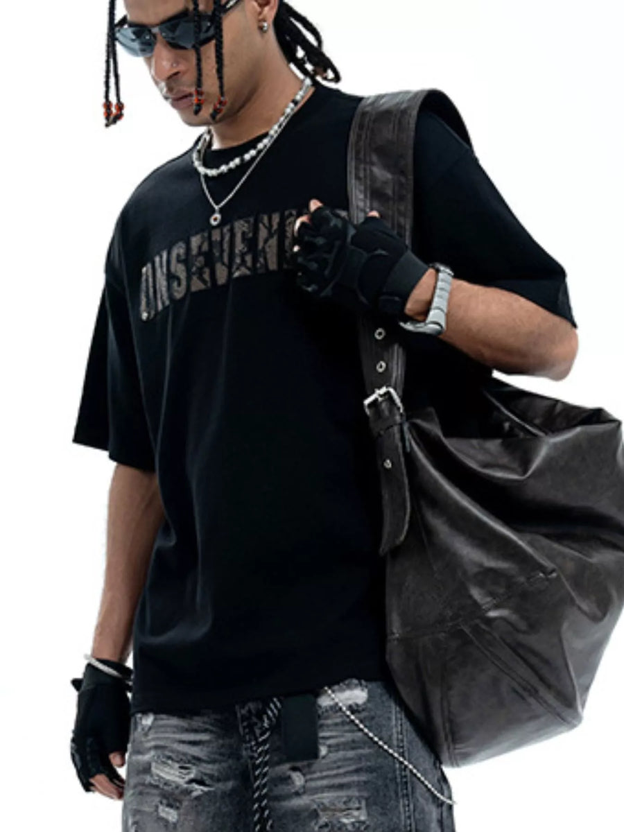 Black oversized cotton t-shirt with distressed logo detail and short sleeves.
