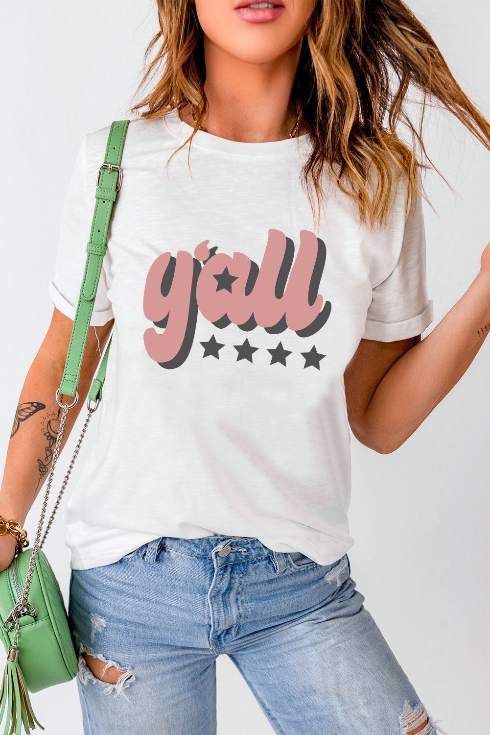 White graphic t-shirt with pink and gray retro "y'all" text and stars.