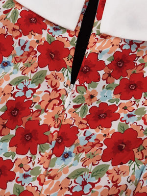 Dress with white Peter Pan collar, red floral print, and zipper detail.
