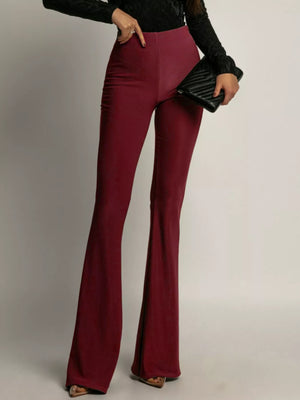 High-waisted flared trousers in red, with a fitted silhouette and wide leg opening.