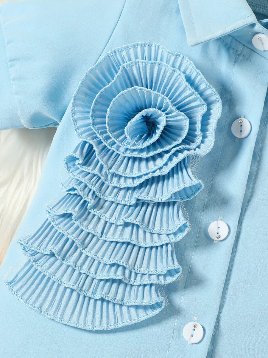 Blue toddler shirt with ruffled floral appliqué and decorative buttons