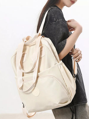 Off-white Oxford cloth backpack with adjustable straps and multiple pockets.