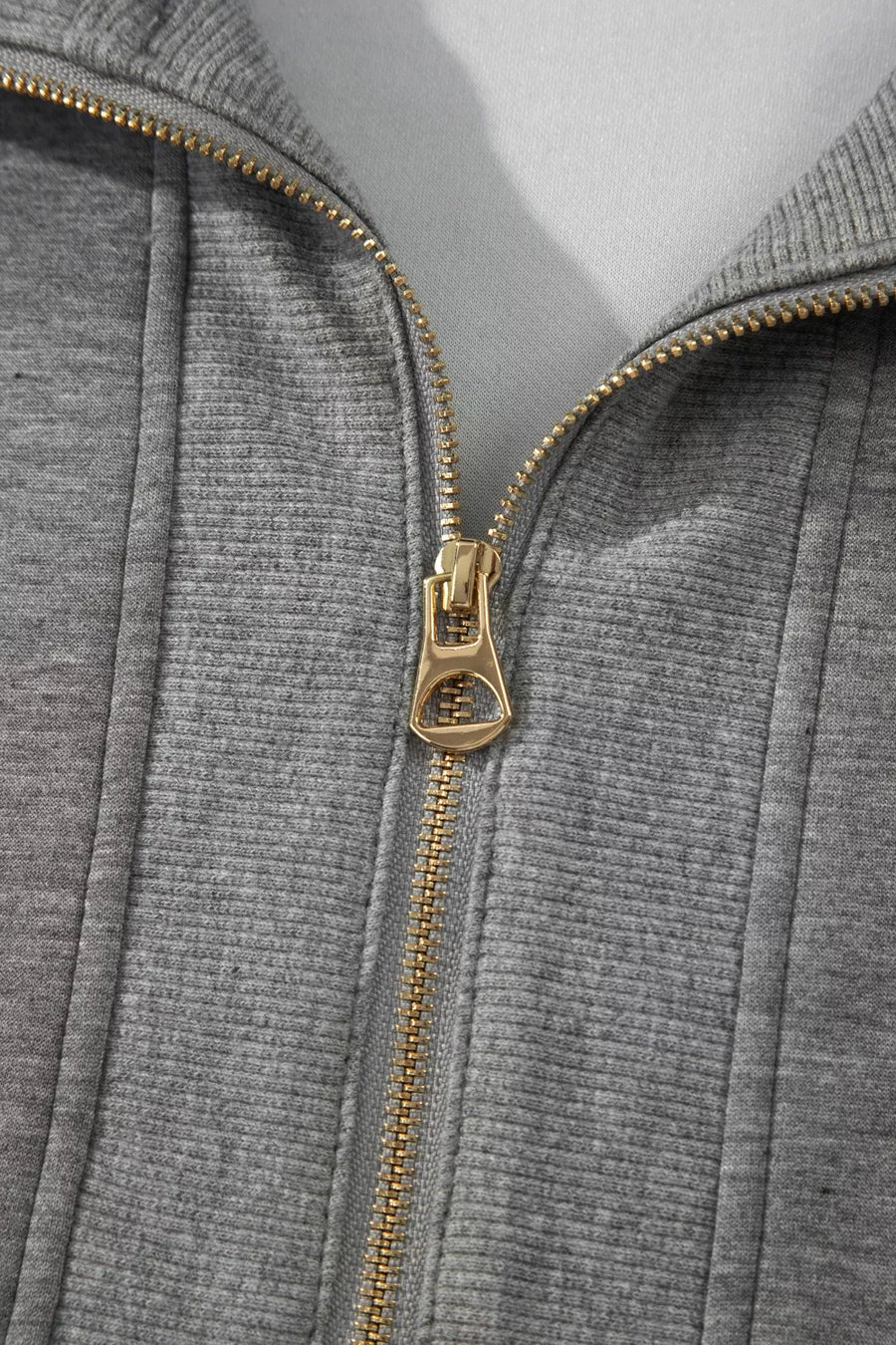 Chic dark gray half-zip polo top with gold zipper detail