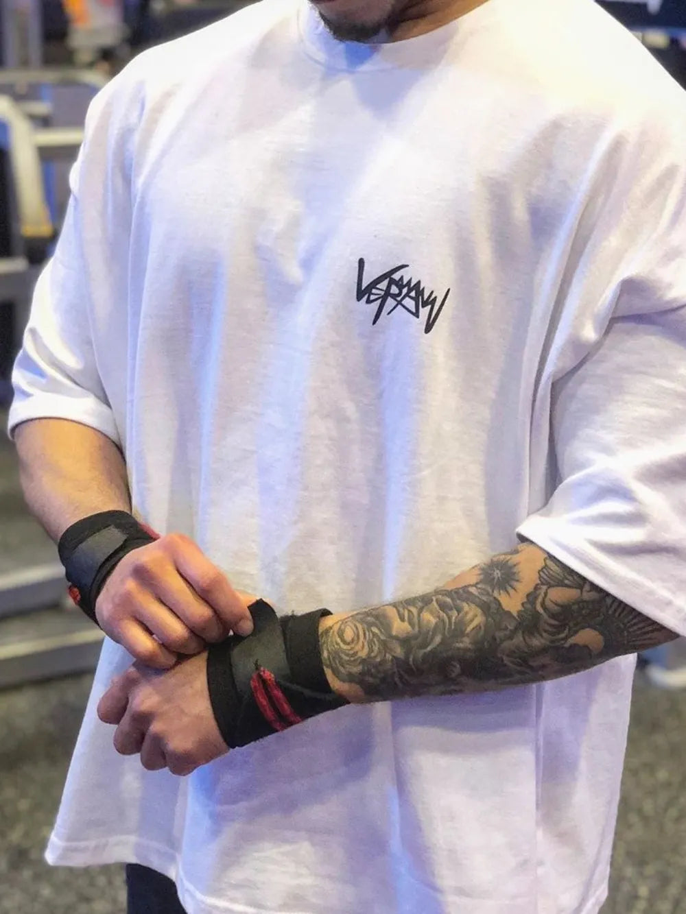 White oversized graphic tee with black logo, short sleeves, crew neck.