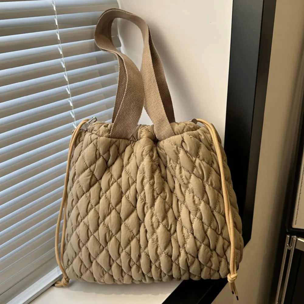 Quilted drawstring carryall handbag in khaki with dual straps and cinched top.