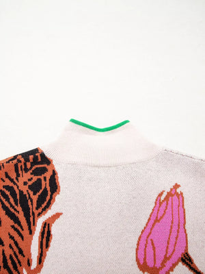 Knit quarter zip sweater with floral pattern and green trim neckline.