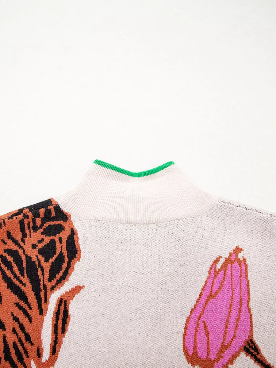 Knit quarter zip sweater with floral pattern and green trim neckline.