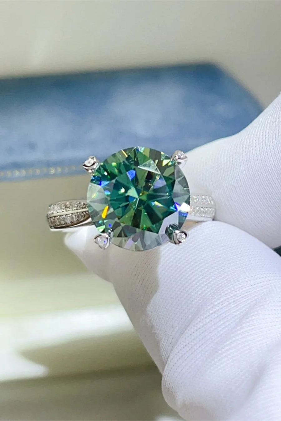 Dark green moissanite solitaire ring with a detailed silver band.