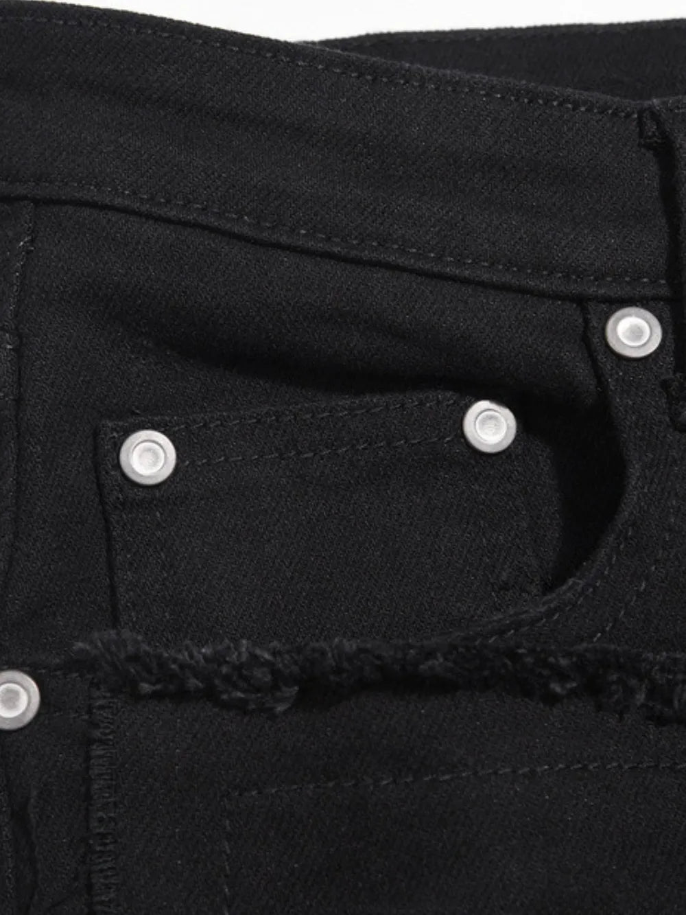 Black denim jeans with frayed hem detail and silver hardware.