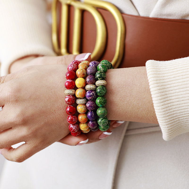 Rainbow Jasper bead bracelets with gold accents in red, orange, purple, and green.