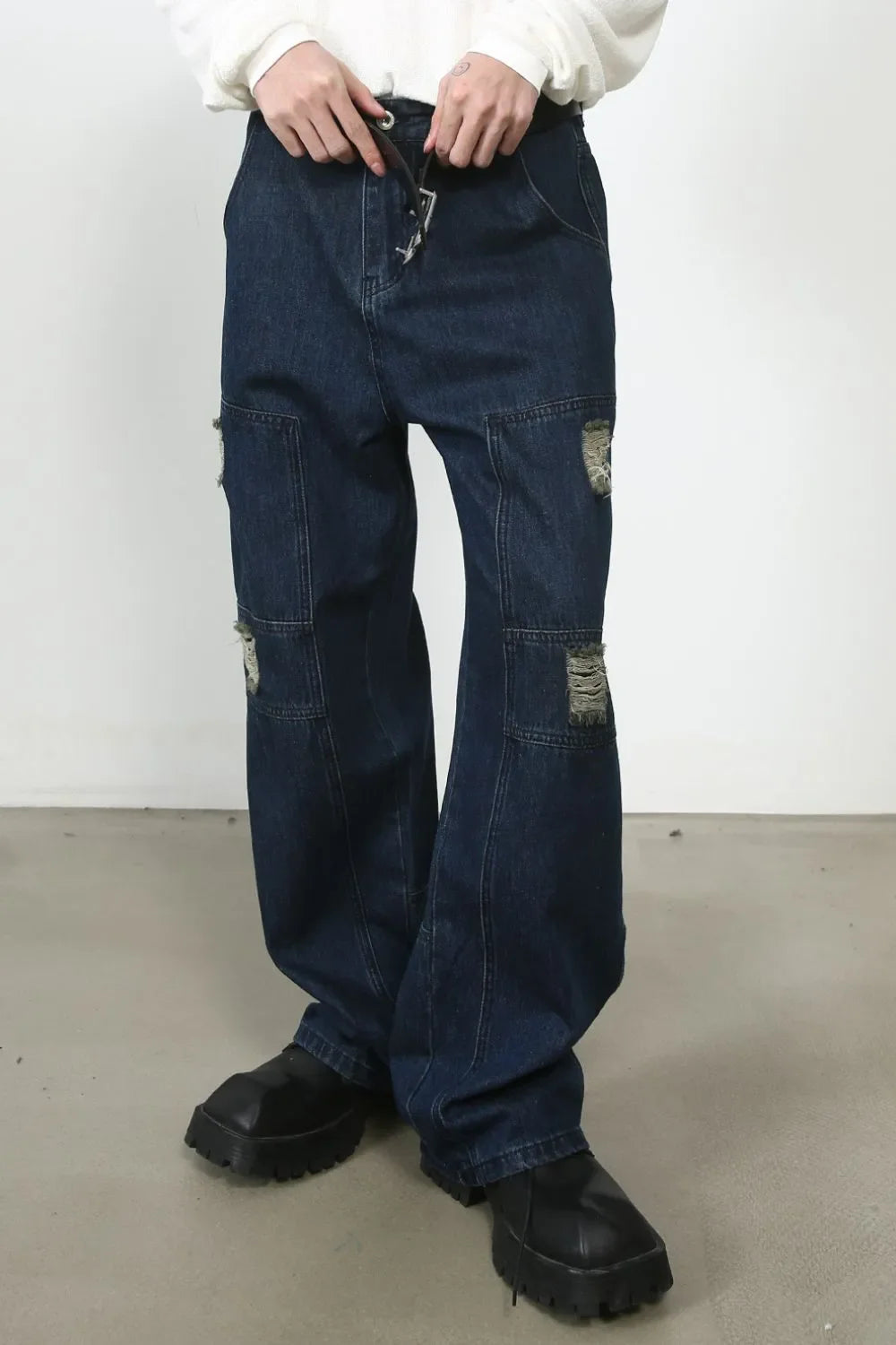 Dark wash denim wide-leg jeans with distressed panel pockets and drawstring waist