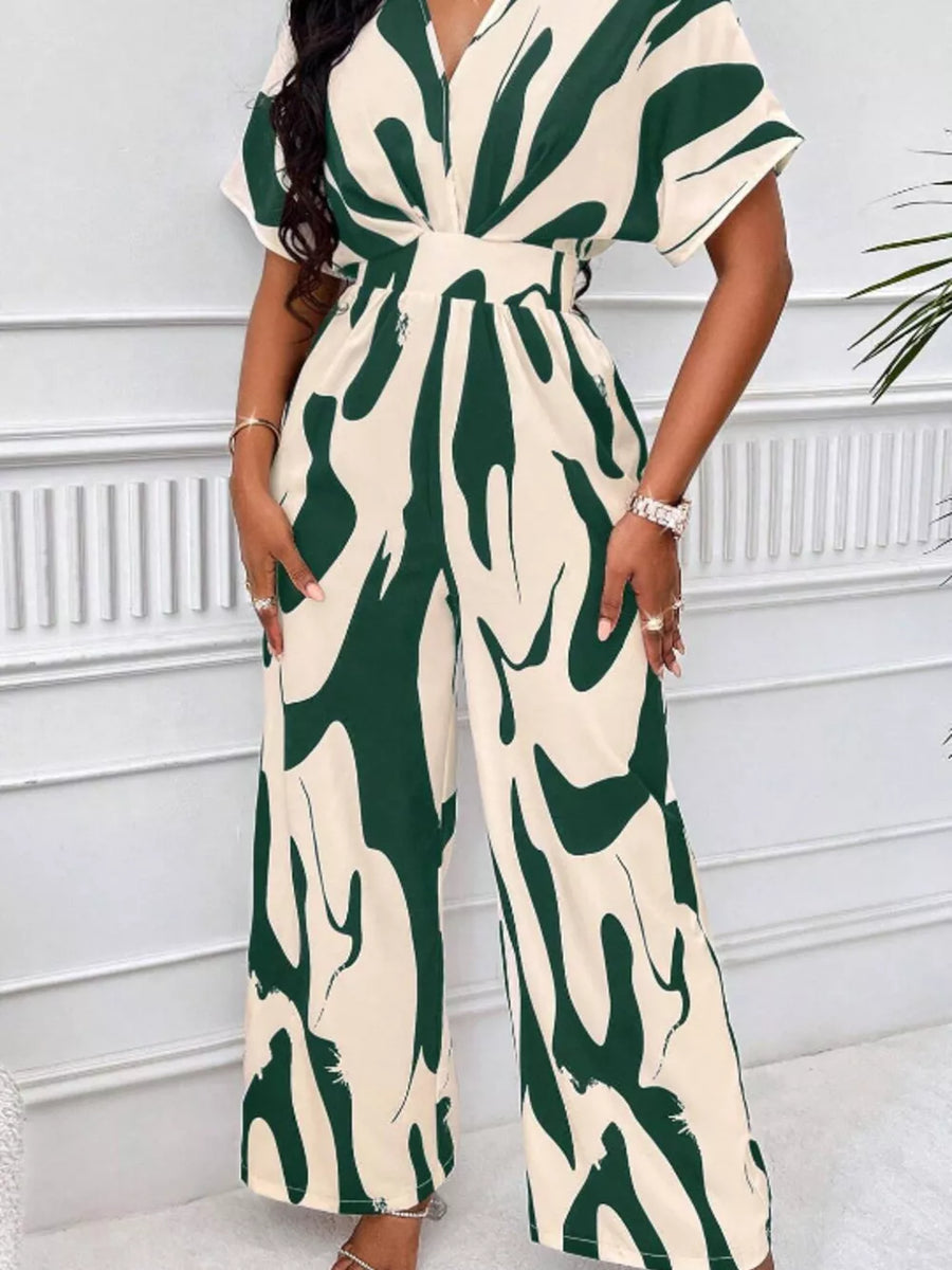 Chic abstract print wide-leg romper in green and cream with short sleeves and a V-neck.