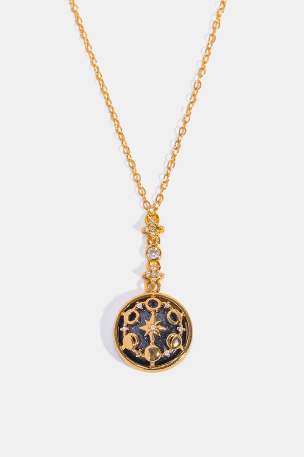Gold celestial medallion pendant necklace with moon phases and star details.