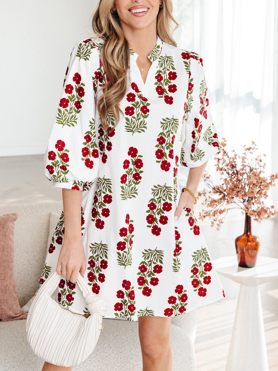 V-neck mini dress with pockets in white with red floral print, cotton fabric, and puff sleeves.