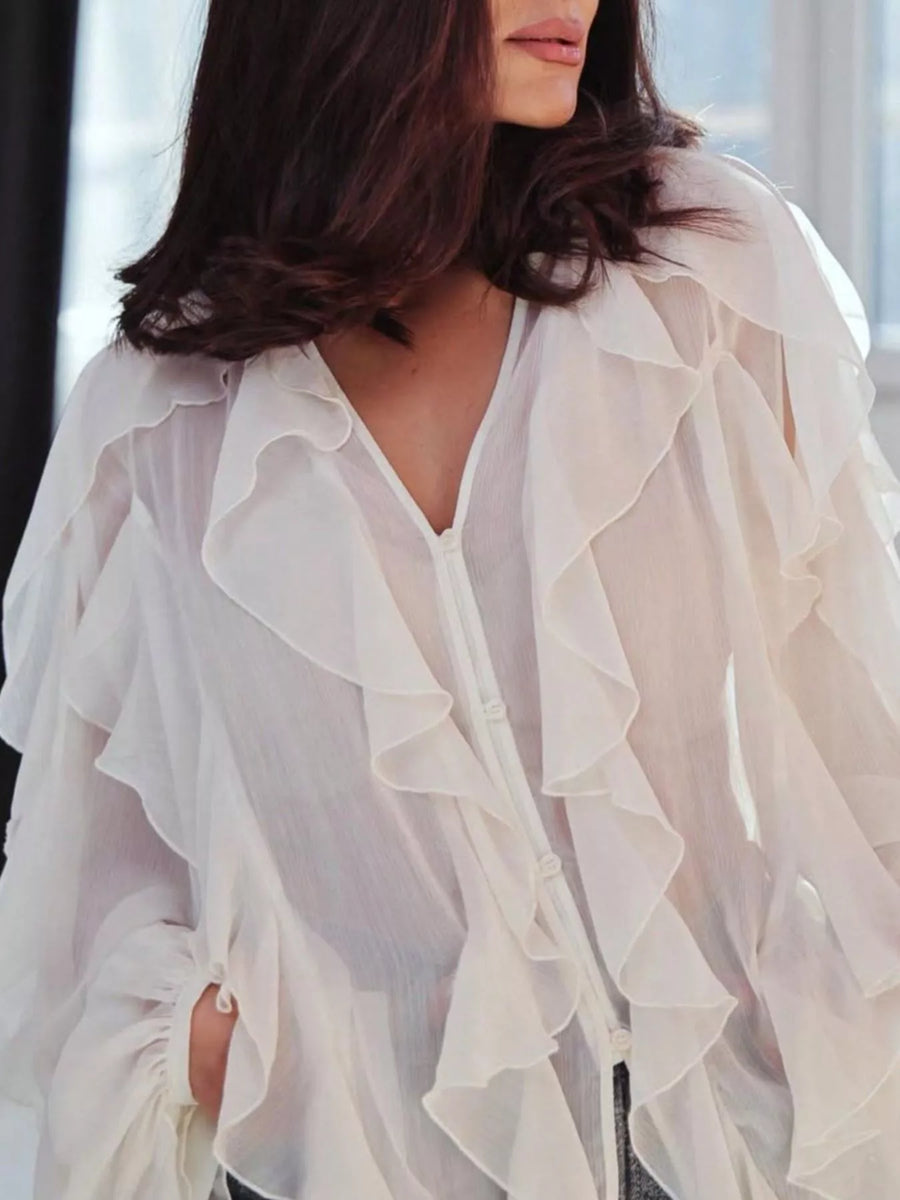 White sheer long-sleeve blouse with cascading ruffles and button front.
