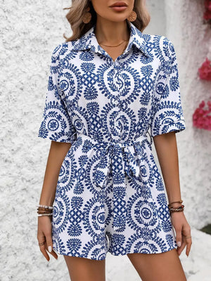 Blue and white printed tie-waist romper with short sleeves and collared neckline.