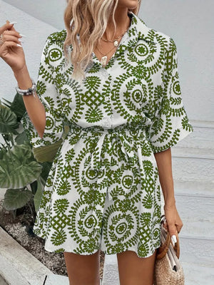Green printed tie-waist romper with button front and short sleeves.