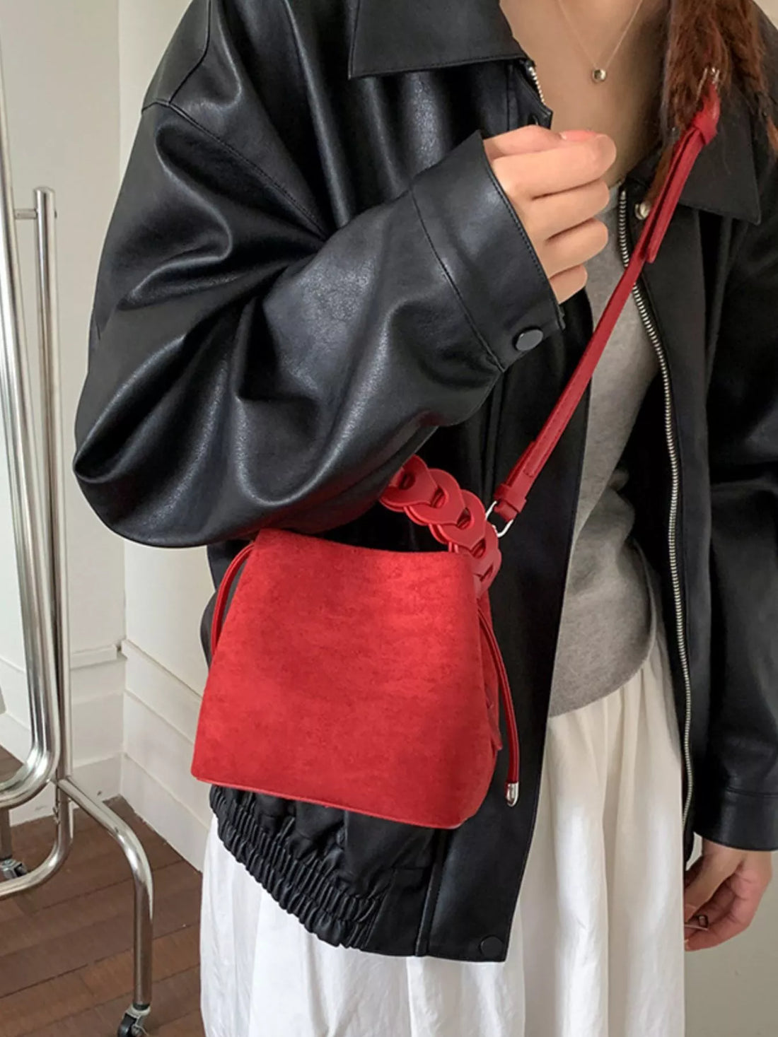 Red mini chain strap crossbody bag with drawstring closure and braided strap detail