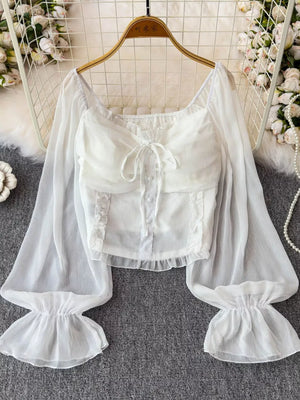 White sheer maternity blouse with ruffled sleeves, bow detail, and button front.