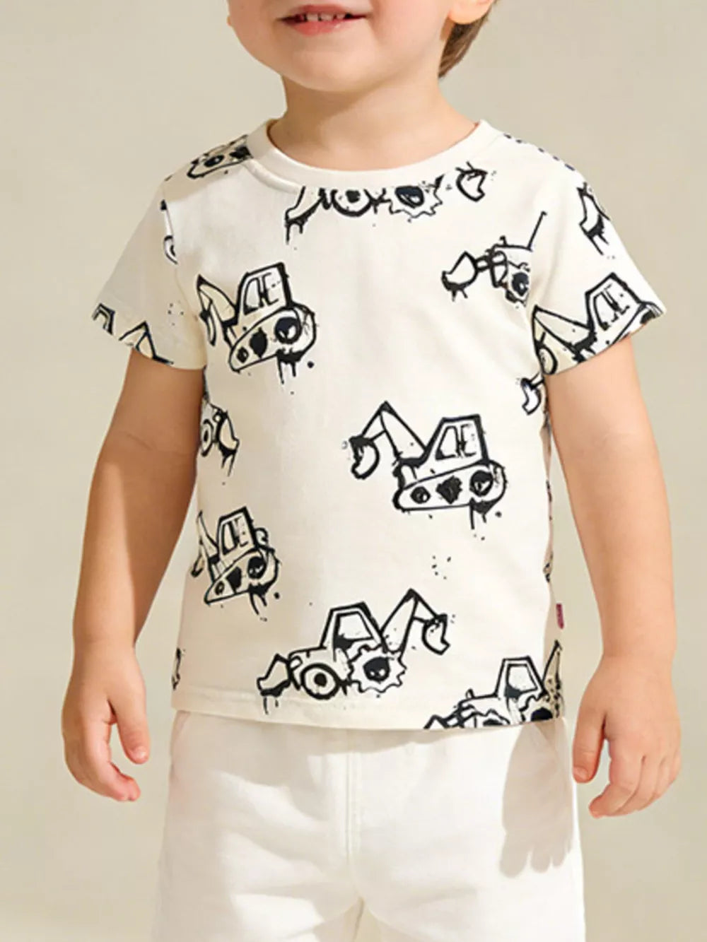 Toddler cream cotton t-shirt with playful black excavator print, short sleeves, crew neck.