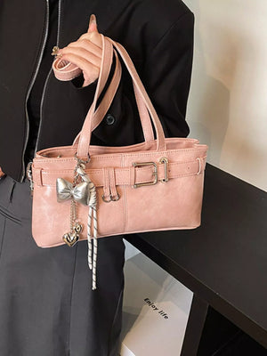Blush pink shoulder bag with buckle detail and bow charm