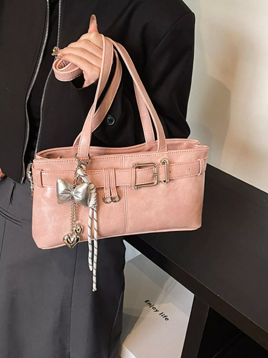 Blush pink shoulder bag with buckle detail and bow charm