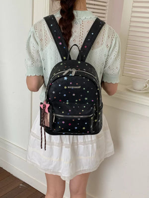 Black mini backpack with colorful star print and star charm detail.