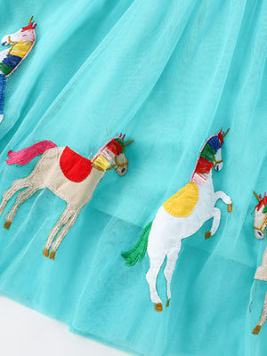Turquoise tulle toddler dress with embroidered colorful unicorns and rainbow manes.