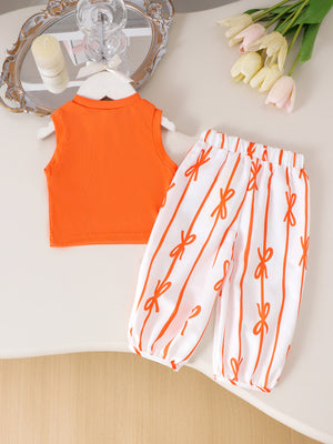 Orange ribbed knit sleeveless top with a collar and white pants with orange bow stripe pattern