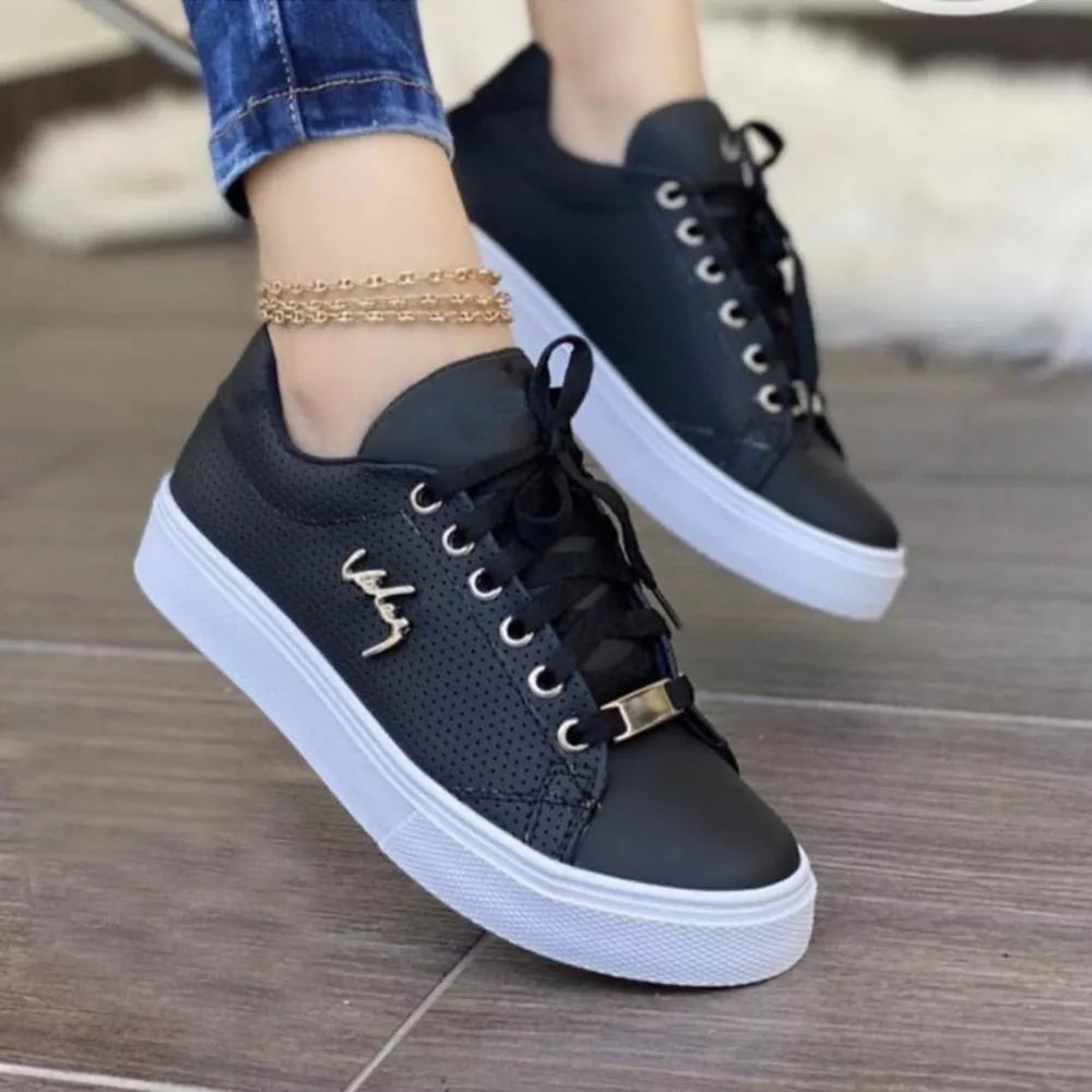 Black perforated lace-up sneakers with gold accents and white soles.