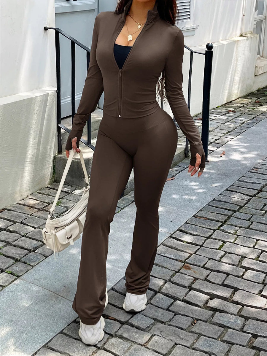 Brown zippered activewear set with thumbhole sleeves and flared pants.