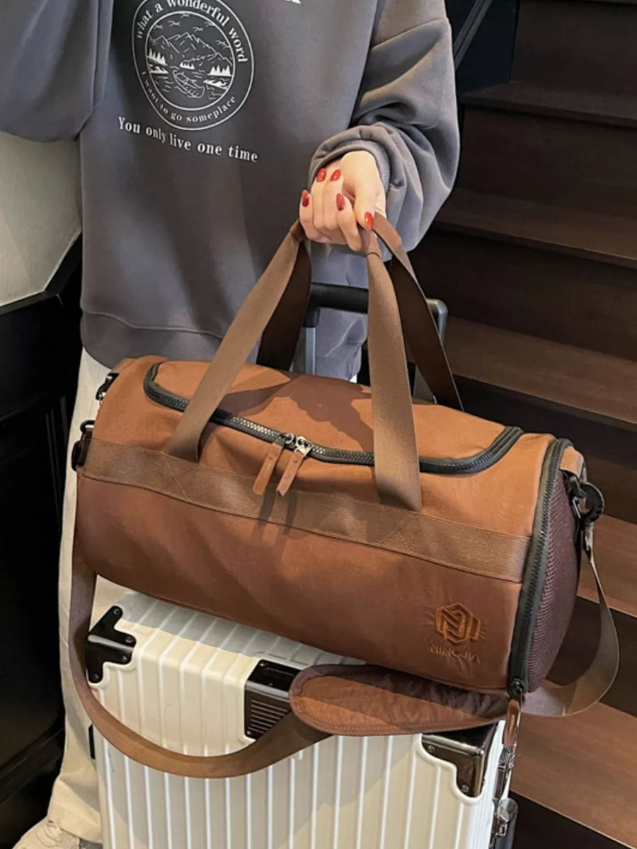 Brown Oxford cloth duffel bag with carry handles and adjustable strap.