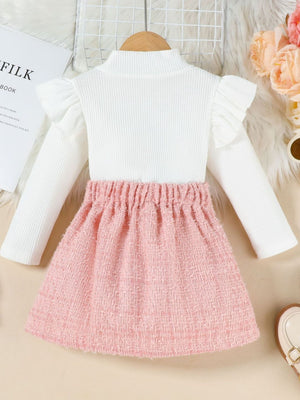 Baby pink tweed a-line skirt with a white ribbed mock neck top with ruffle sleeves.