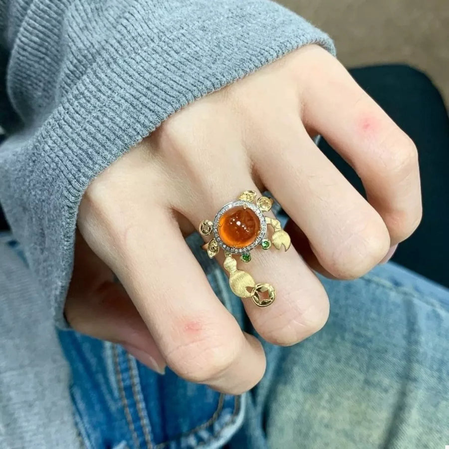 Gold crab ring with orange gemstone and diamond accents