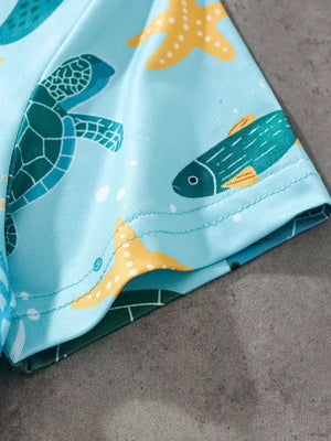 Light blue t-shirt with a playful sea creature print featuring turtles, fish, and starfish.