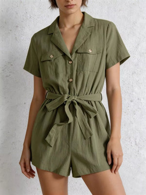 Olive green cotton romper with short sleeves, collared neckline, button-down front, chest pockets, and tie waist.