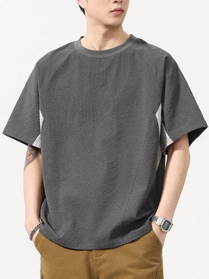Men's dark gray textured t-shirt with contrast panels and crew neck.