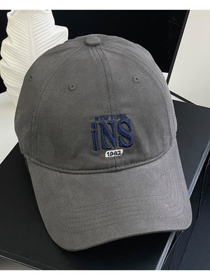Grey baseball cap with embroidered INS New York 1982 detail