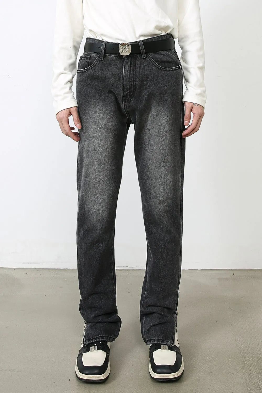 Dark washed denim trousers with split hems and a casual fit.