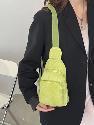 Yellow green corduroy sling bag with zip pockets and adjustable strap.