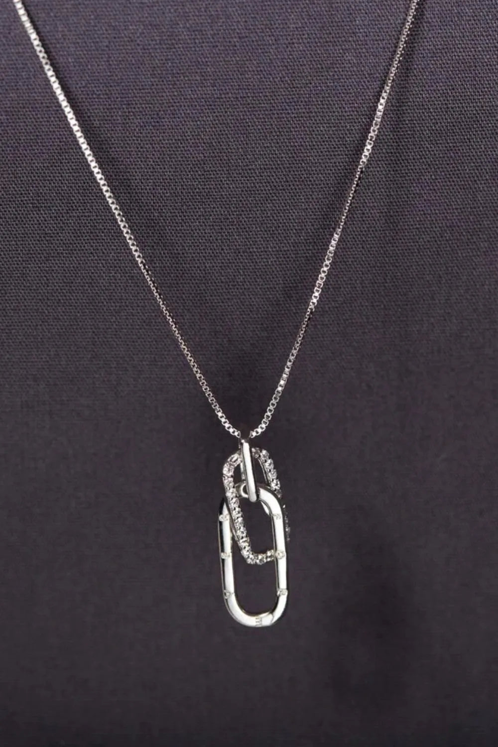 Silver linked pendant necklace with zirconia accents on a delicate chain.